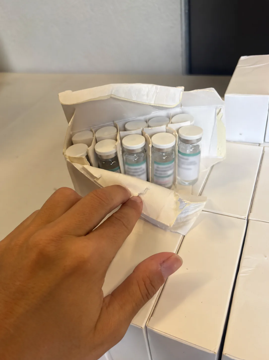 Opened carton of ten 10 mL bacteriostatic water vials in cardboard dividers